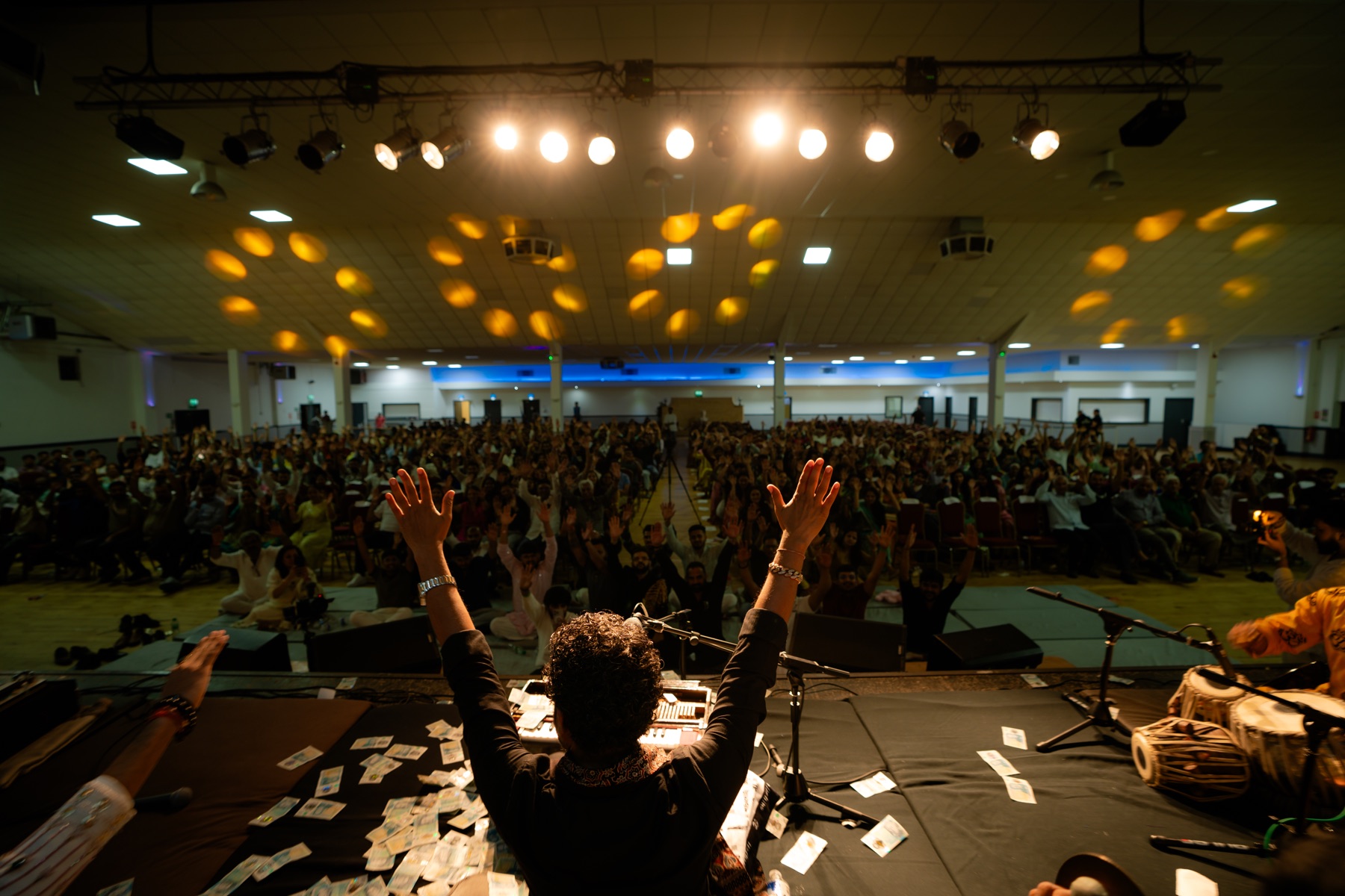 A packed live audience seen from the stage